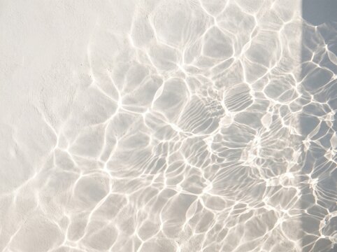 Bright caustic light patterns reflecting from water onto a solid concrete surface