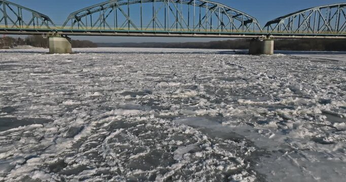 Brda River with ice with a metal bridge in Poland.