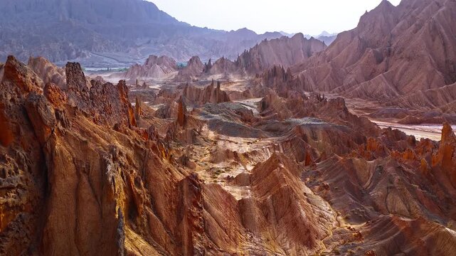 Aerial view of sharp eroded sandstone peaks and jagged ridges in the arid canyons of the Red Mountain Stone Forest, Kuqa, Xinjiang, China
