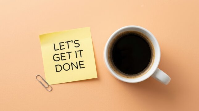 Yellow sticky note displaying lets get it done message beside a white ceramic cup filled with hot black coffee