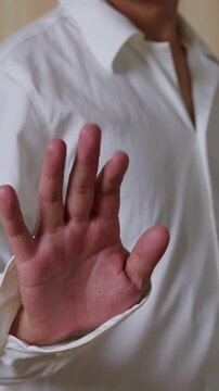 Vertical video: Hand gesture meaning rejection. Waving hand towards camera. Human hand gesture, common hand movement.