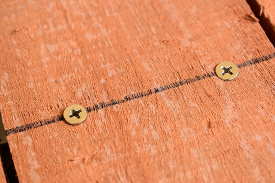 natural reddish brown wooden board texture background with visible screw