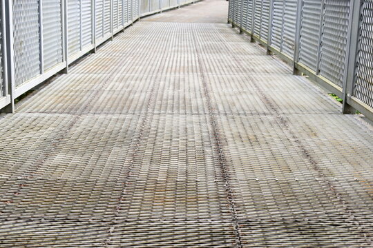 steel mesh canopy walk bridge walkway extending into green jungle