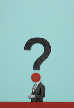 Paper cutout businessman standing under large question mark on blue background