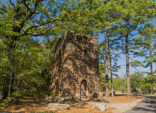 Stone tower structure in a wooded park setting