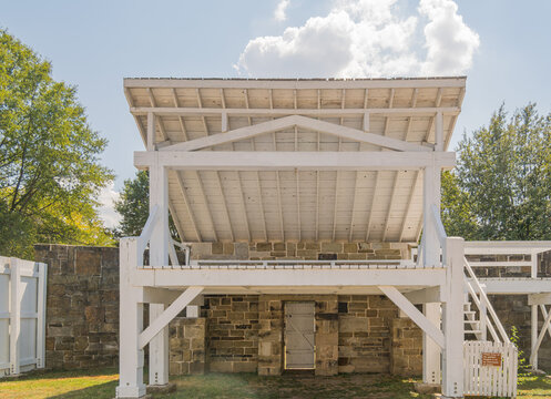 White wooden structure over stone ruins at historic site