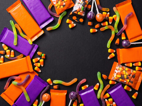 Halloween candy border on a black background with various sweets and treats.