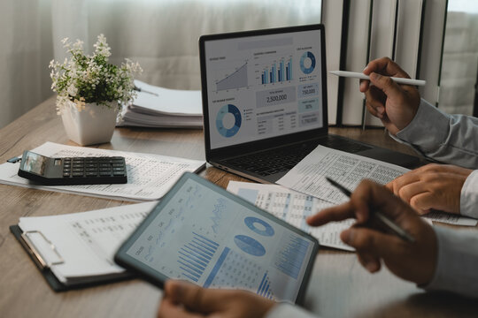 Business team reviewing accounting financial reports and tablet dashboards, reviewing business reports for performance analysis and financial reporting.