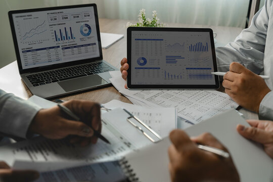 Business team reviewing accounting financial reportsand tablet during business discussion, reviewing charts and tables for data analysis and reporting.