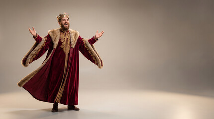 Fototapeta premium King in royal robe laughing with arms wide open