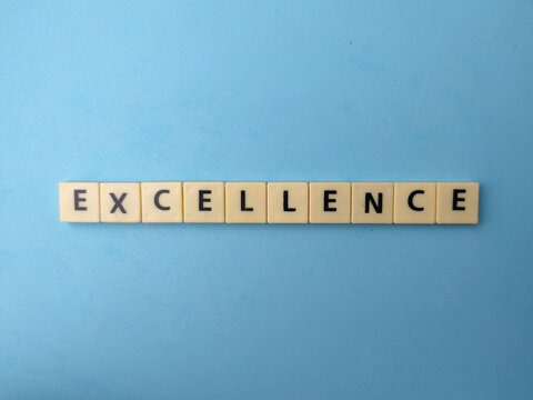 Letter tiles spell out the word EXCELLENCE horizontally aligned in the middle of a smooth blue surface