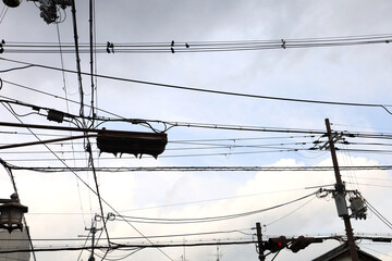 Densely webbed power lines over street lights. © Bowonpat