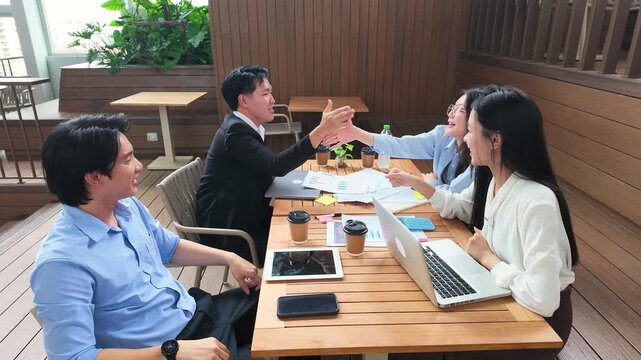 Asian Business Team Celebrating Success with High Fives on Office Terrace
