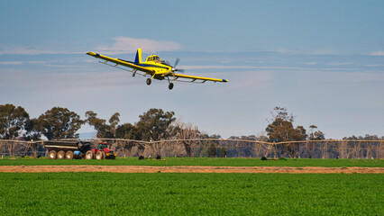 Crop duster flies past tractor on Yarrawonga paddock © Alistair