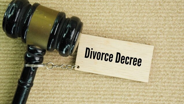 Judge's gavel and wooden tag with the words divorce decree is a final, legally binding court order signed by a judge that officially ends a marriage and outlines the specific terms of the split.