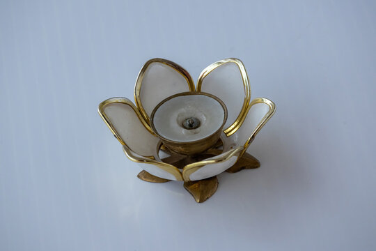 Vintage lotus flower shaped candle holder with white capiz shell petals and brass trim isolated on seamless plain background.