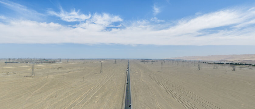 Aerial View of Straight Gobi Desert Highway with Power Transmission Towers in Dunhuang