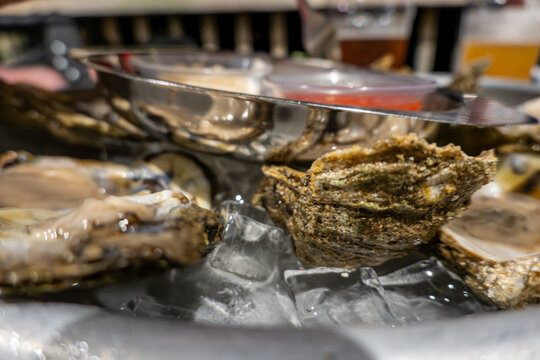 Solomons, Maryland USA A serving of a dozen raw oysters in their shell on ice with horseradish and hot sauce.