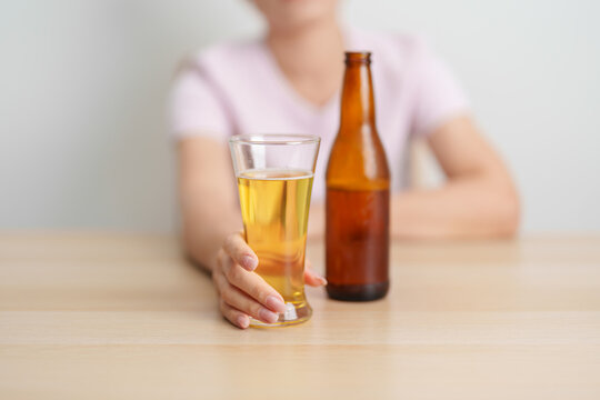 woman with glass of Beer on table, suffering from alcohol addiction and alcoholism concept. depicting emotional distress, depression, substance abuse problem, unhealthy lifestyle and mental health