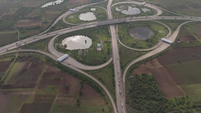 Aerial drone view of large highway interchange with circular road ramps and agricultural land in Bharuch Gujarat India