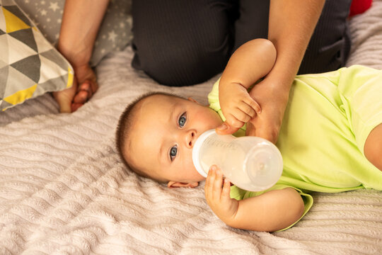 Mother Helps Baby Son Drink Milk From Bottle