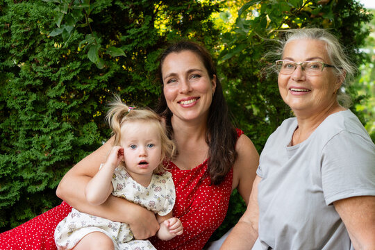 Smiling Three Generation Family Portrait in Summer Garden