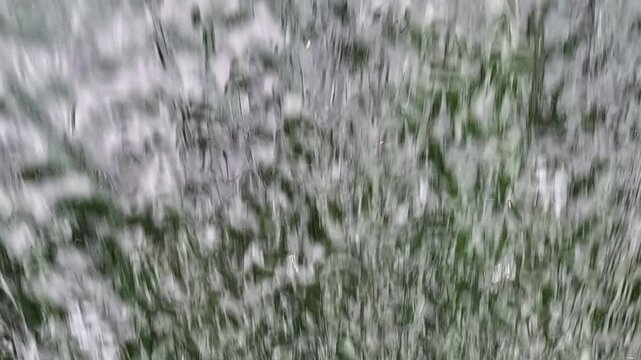 A close-up of blurred fast-flowing white water in a rocky stream, creating a streaky pattern of movement as the current moves evenly across the frame.