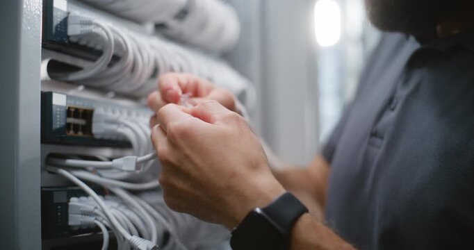Data Center Technician Terminates Cat6 Cable With RJ45 Connector, Using Crimping Tool to Secure Contacts and Prepare Precise Length Patch Cord for Professional Network Infrastructure Maintenance.