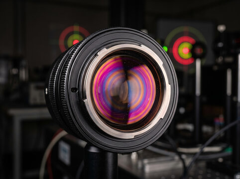 Professional optical camera lens with colorful glass coating reflection in laboratory