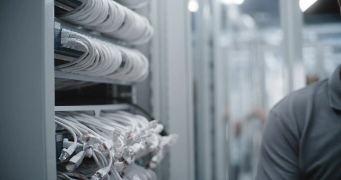 Male Technician Upgrades Network Infrastructure by Installing New Rack Mounted Switch, Replacing Faulty Equipment and Restoring Connectivity Within Modern Data Center During Scheduled Maintenance.