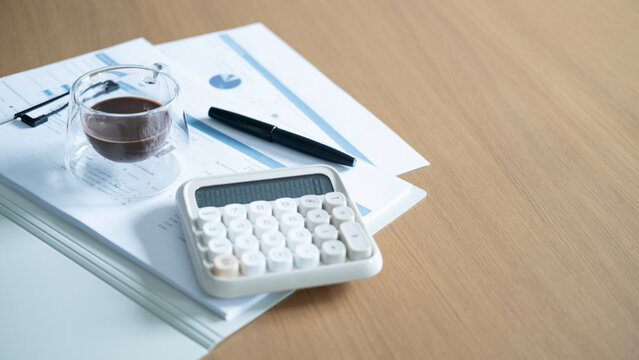 Coffee and calculator on financial documents with large copy space. Business budgeting, accounting, investment planning and financial analysis workspace concept.