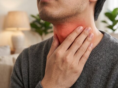 Man with sore throat touching inflamed neck. Respiratory illness and healthcare concept.