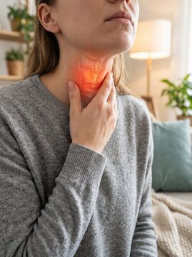 Woman touching neck experiencing sore throat with glowing red anatomical graphic