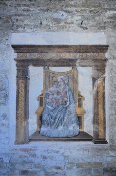 San Gimignano, Italy 03.04.2020: Madonna and Child Enthroned, a 15th-century work located under the Loggia of the Palazzo del Popolo
