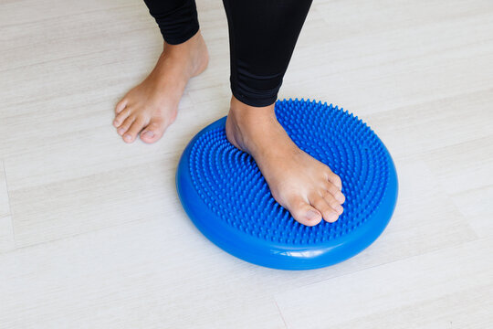 Barefoot standing on a massage balance cushion supports proprioception, plantar reflex stimulation, postural control and preventive rehabilitation of feet and ankles.