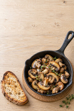 Gebratene Champignons mit Thymian in einer Gusseisenpfanne