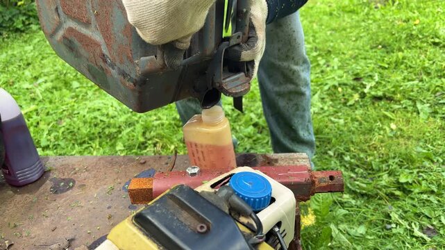Worker Refueling a Gas Powered Garden Trimmer
