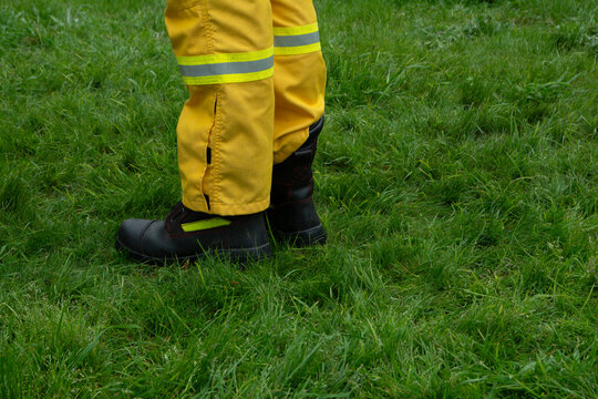 legs and boots of firefighters wearing yellow protective uniforms