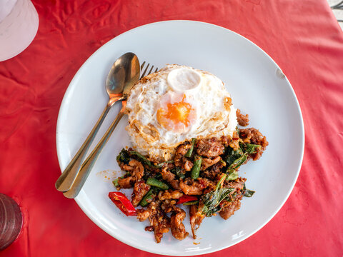 Thai Stir-Fried Pork with Red Curry Paste Served Over Rice with Fried Egg