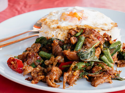 Thai Stir-Fried Pork with Red Curry Paste Served Over Rice with Fried Egg