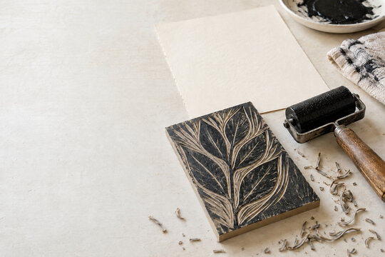 Geschnittener Druckstock mit Blattmotiv und Farbwalze im Atelier