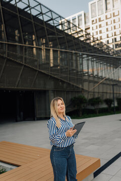 Businesswoman holding digital tablet standing in modern city