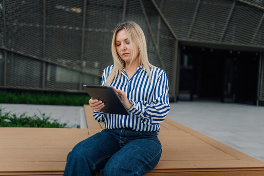 Woman using digital tablet outdoors for business work