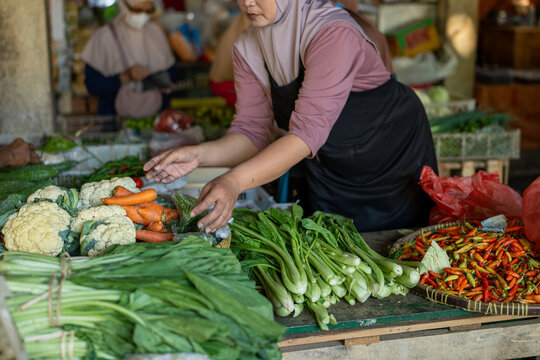 Vendor selling fresh vegetables at traditional indonesian market