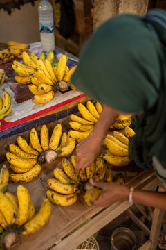 Street vendor displaying yellow bananas at a fruit market