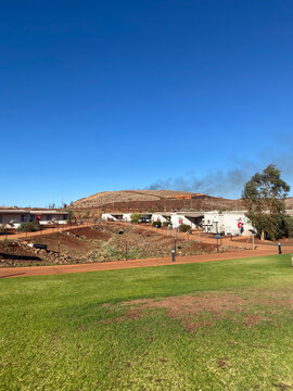 Bushfire burning on a hill near buildings and grass