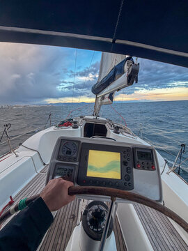 Hand steering sailboat at sea navigating ocean
