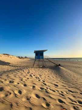 Lifeguard stand on sandy beach at sunset