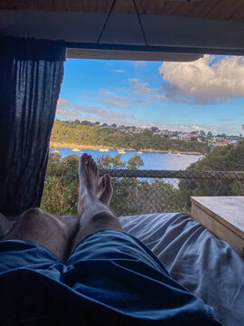 Legs relaxing in camper van viewing bay harbor