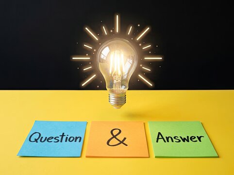 Glowing light bulb over Question Answer notes suitable for FAQ and business education symbolizing creative solutions and innovation